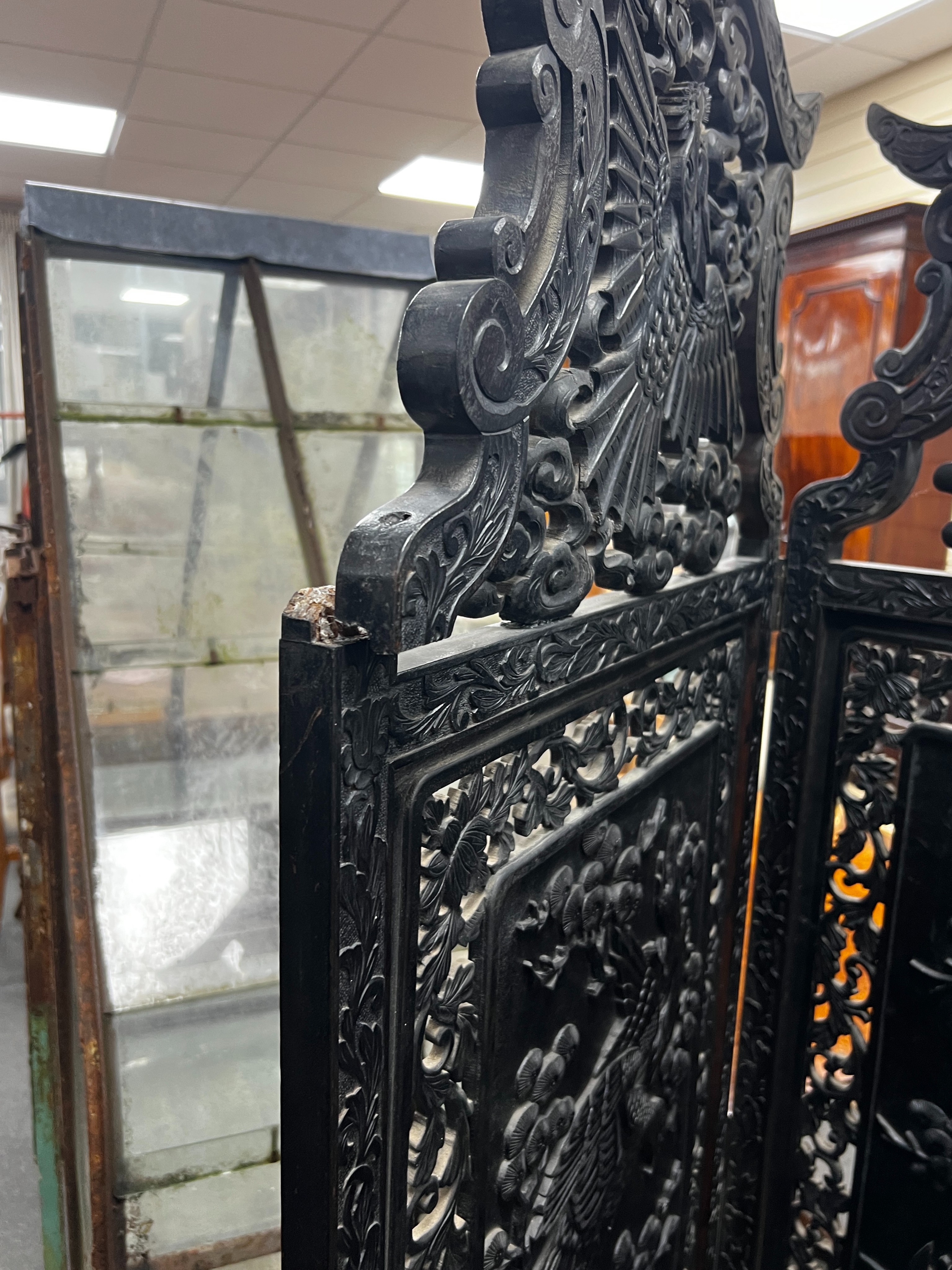 An early 20th century Japanese carved ebonised wood four fold dressing screen, width 56cm, height 173cm